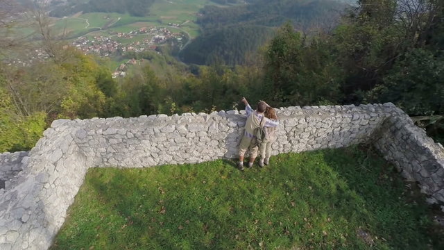 Couple admiring the view from castle ruins 