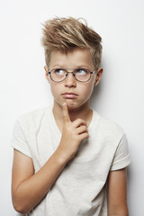 Thoughtful young boy looking up, studio