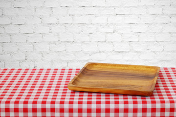 Empty wooden tray on table with red tablecloth