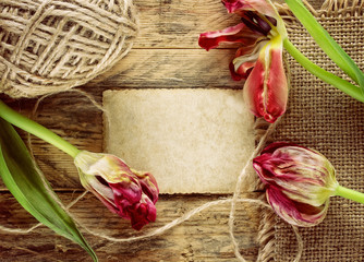 three dried tulips on a wooden table