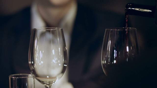 Sommelier pouring red wine into a glass