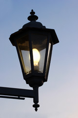 Fototapeta na wymiar Dirty old street lamp against twilight background