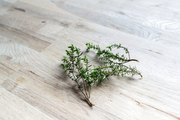 fresh branch of thyme on an oak tree cutting board