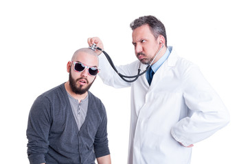 Male doctor consulting a crazy patient with stethoscope