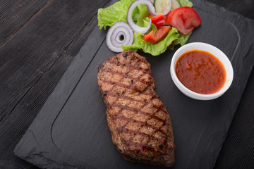 beef steak on with fresh salad on stone