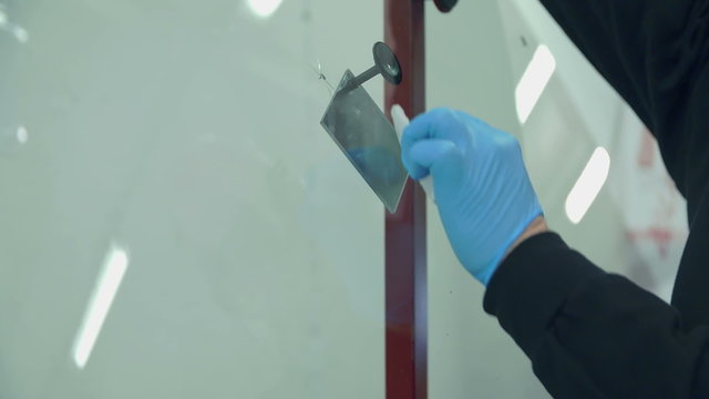 Worker is mending a broken glass on the front window