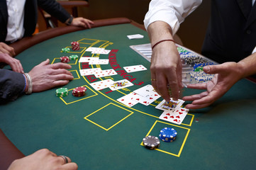 A close up of a blackjack dealer's hands in a casino, very shallow depth of field - obrazy, fototapety, plakaty