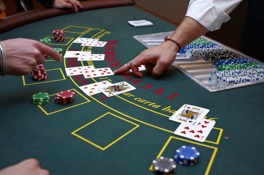 A close up of a blackjack dealer's hands in a casino, very shallow depth of field