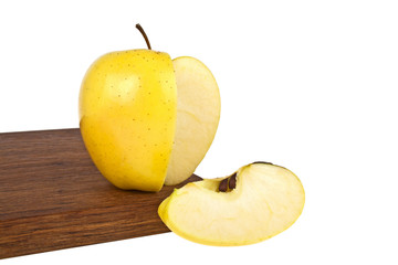 Naklejka na ściany i meble Yellow apple and slice on wooden cutting board on a white backgr