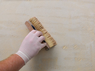 Applying plaster on the wall using a roller