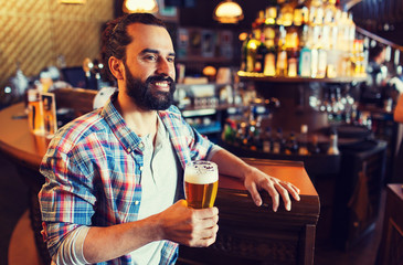 happy man drinking beer at bar or pub