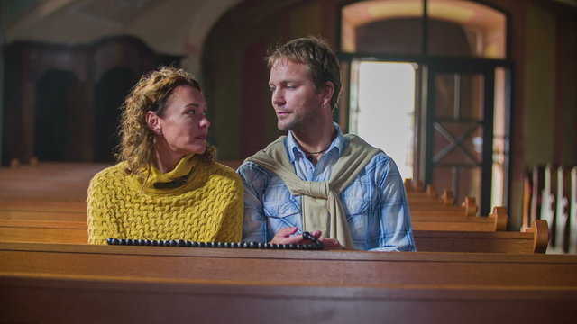 Couple gets out of wooden benches in the church