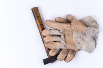 Old dirty hammer with used working leather gloves