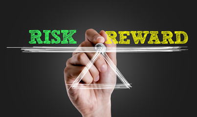 Hand writing the text: Risk vs Reward