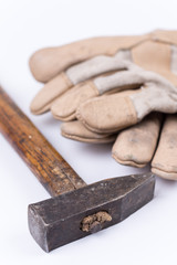 Old dirty hammer with used working leather gloves