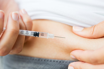 woman with syringe making insulin injection