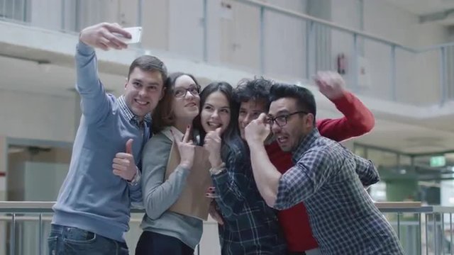 Group of young multi-ethnic students are making selfie photos in an university. Shot on RED Cinema Camera.