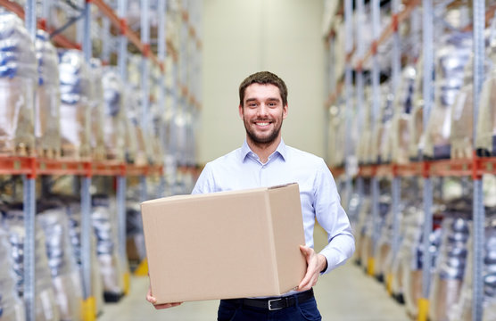 happy man with cardboard parcel box at warehouse