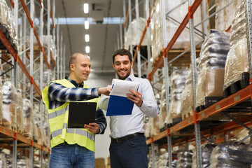 worker and businessmen with clipboard at warehouse - obrazy, fototapety, plakaty