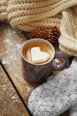 Cup of coffee with marshmallow on wooden table