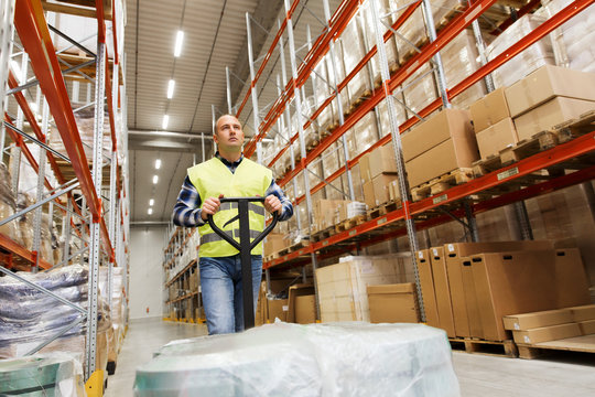 man carrying loader with goods at warehouse