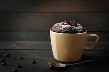 Chocolate fondant cake in cup on wooden background