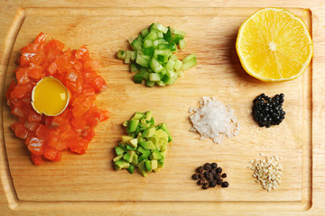 Tasty ingredients of salmon tartare on cutting board, flat lay