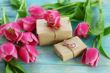 Fresh pink tulips on a wooden table, top view