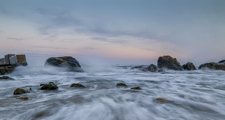 Sea with waves crashing on the rocks, gentle transitions, blur, splash, sunset (sunrise), quiet atmosphere, intimate. The coastline of the surf. Art photo.
