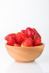 Fresh red strawberries in a wooden bowl isolated on a white