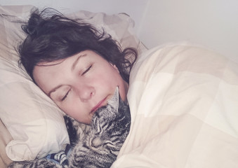 süßes Kätzchen schläft im Bett mit Besitzer