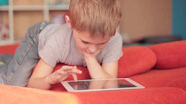little boy playing on the tablet computer games