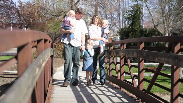 Family crossing wooden bridge