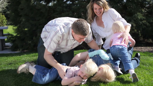Family playing in grass at park