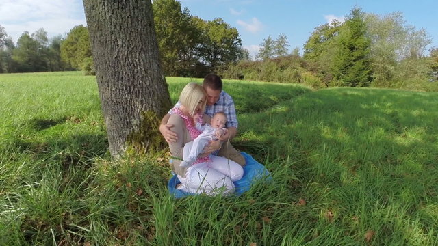 Mother and father with child under a tree spending magical moment together