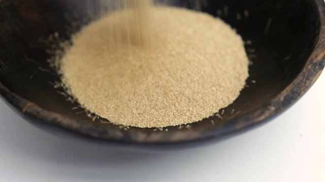 Amaranth seeds pouring into rustic bowl close-up Isolated video 