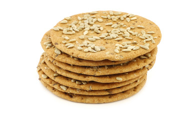 stacked crispy spelt crackers with sunflower seeds on a white background