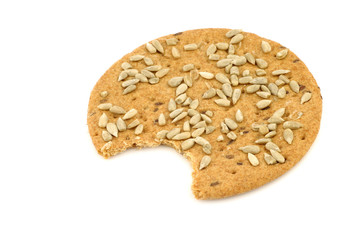 crispy spelt cracker with sunflower seeds with a bite missing on a white background