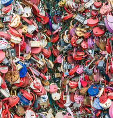 Fototapeta na wymiar Traditional wedding multicolor padlocks hang on the wall. Can be used as background