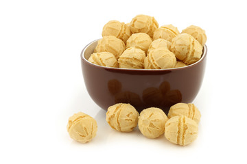 tasty cheese balls in a brown bowl on a white background