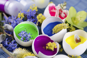 Easter decoration with spring flowers and  tempera paint in an egg shell and tubes 