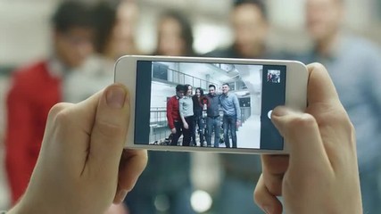 First view footage of a person taking a picture of students with a smartphone. Shot on RED Cinema Camera. - Powered by Adobe