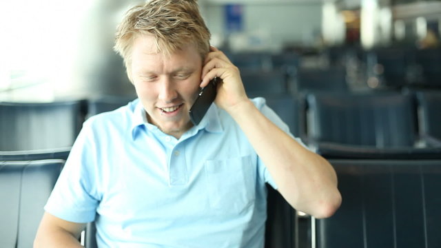 Young man with cell phone at airport