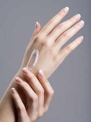 Close-up female hands apllying hand cream