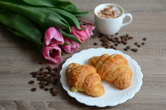 cup of cuppuccino and yummy croissants with flowers