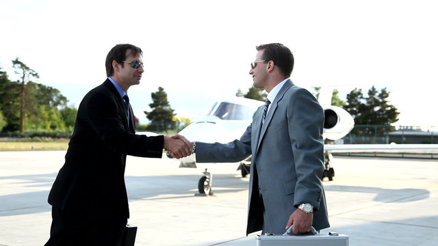 Businessmen meet in front of jet
