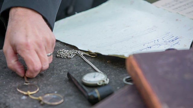 Man picking up the glasses while writing 