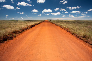 Rural orange dirt road with blue sky and far horizon © tacio philip