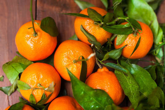 Fresh mandarin oranges fruit with leaves on wooden table / top v