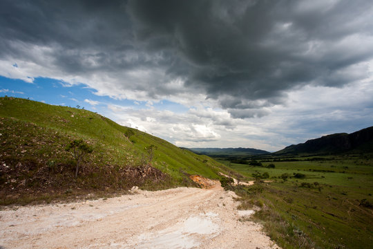Rural dirt road with dark storm sky